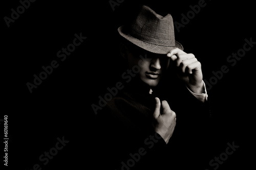 low key portrait of young gangster with hat in the darkness. photo