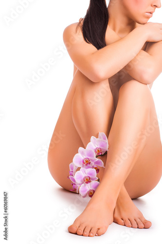 nude woman with orchid flower on white