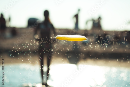 Photos frisbee in a spray of water against the beach