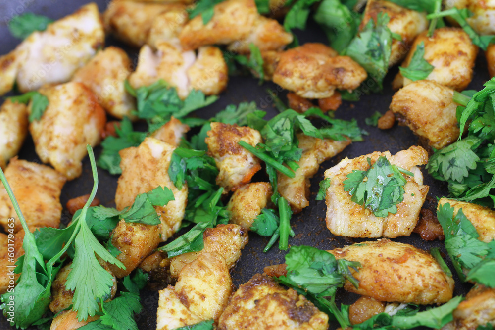 Fried chicken with coriander in frying pan Fried chicken with coriander in frying pan