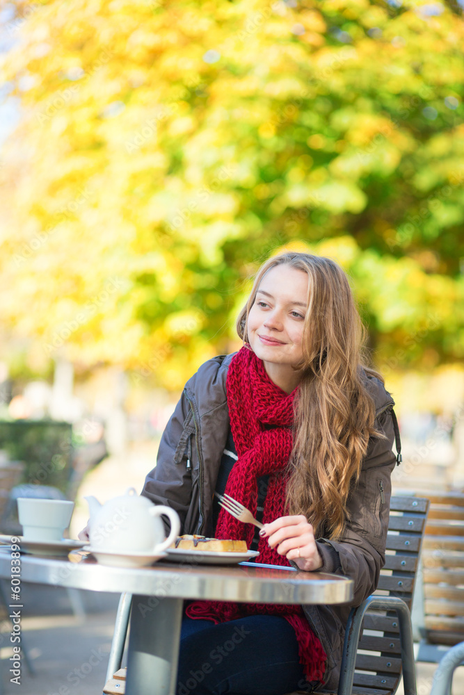 Girl eating waffles in a Parisian outdoor cafe Girl eating waffles in a Parisian outdoor cafe