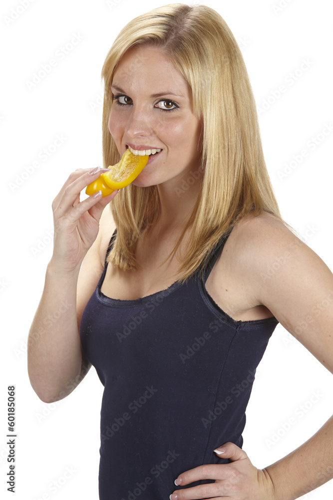 Junge Frau isst gelbe Paprika - Gesunde Ernährung Junge Frau isst gelbe Paprika - Gesunde Ernährung