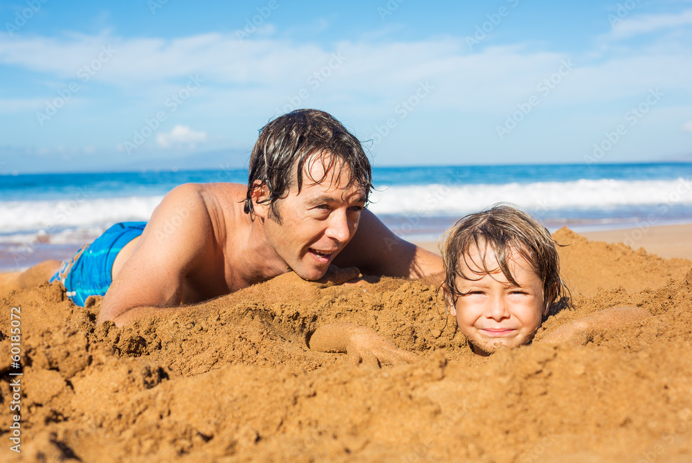 Fototapeta premium Father and son playing together in the sand on tropical beach