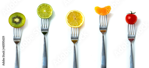 MIx of fruits and vegetables on forks in white background