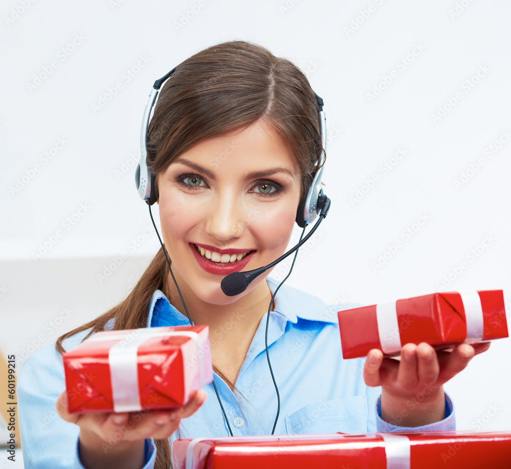 Smiling operator seat at table with red gift box. Happy busines