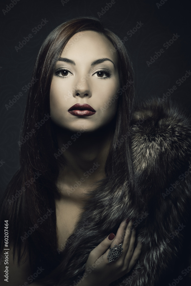 Woman beauty portrait in luxury fur coat. Dark background. Woman beauty portrait in luxury fur coat. Dark background.