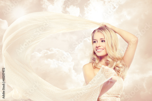 Happy beautiful blonde woman carefree dancing with flying fabric