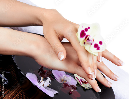 Woman's hands with orchids and bowl of water