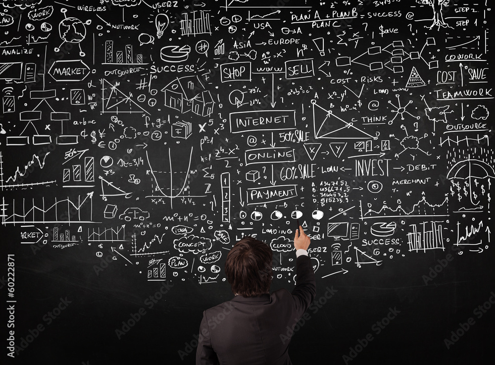 Businessman standing in front of drawn charts on a blackboard Businessman standing in front of drawn charts on a blackboard