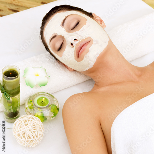 Woman at spa salon with cosmetic mask on face .