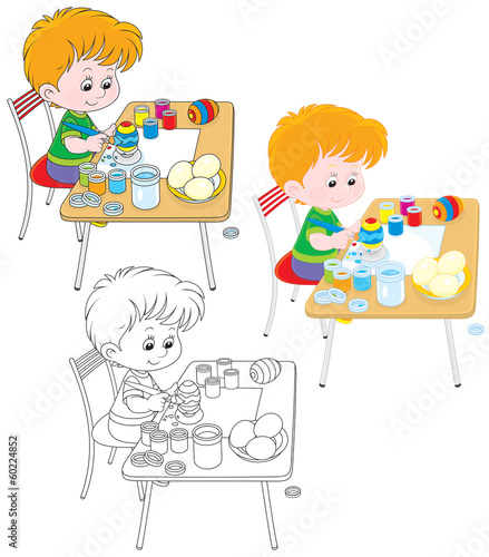 Boy paints Easter eggs