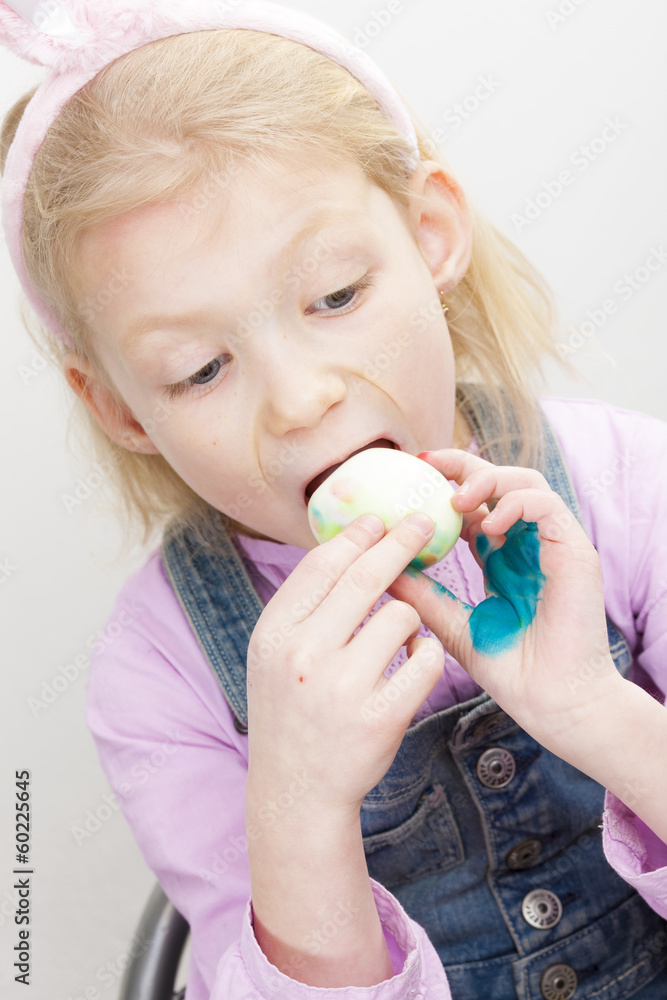 portrait of little girl eating Easter egg portrait of little girl eating Easter egg