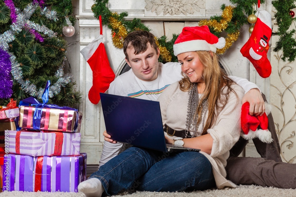 Family with notebook near Christmas tree. Family with notebook near Christmas tree.