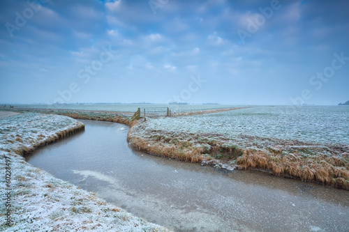 frozen canal on Dutch farmland photo