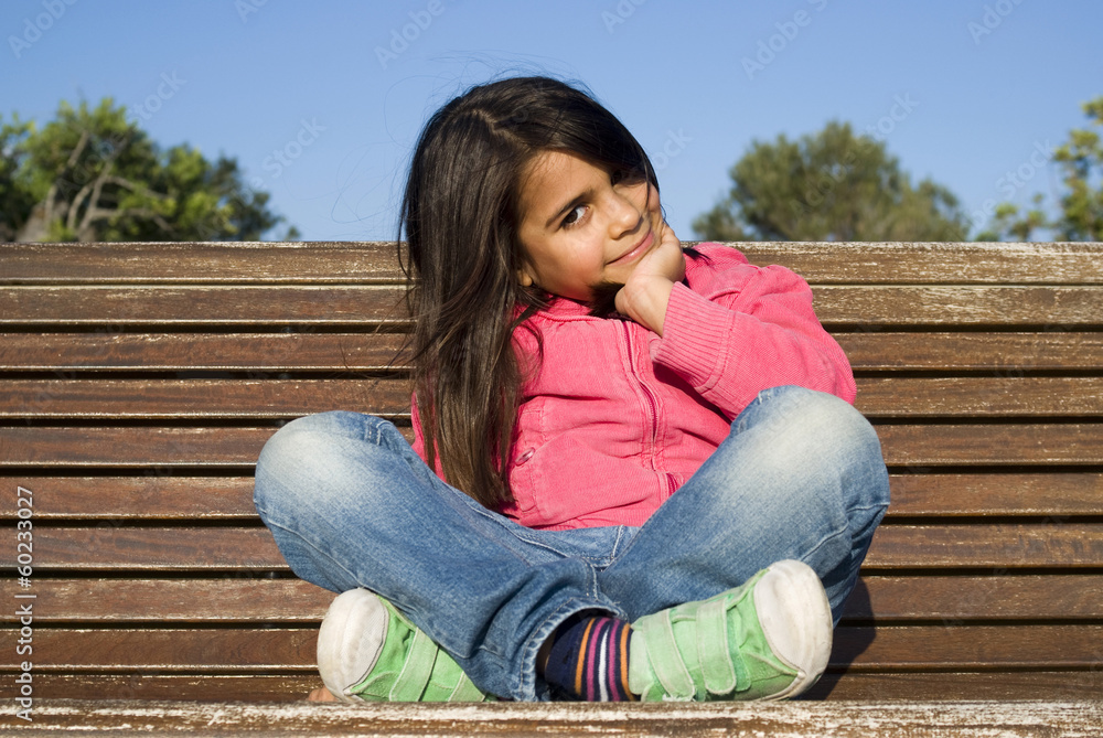 The little girl sitting on bench The little girl sitting on bench