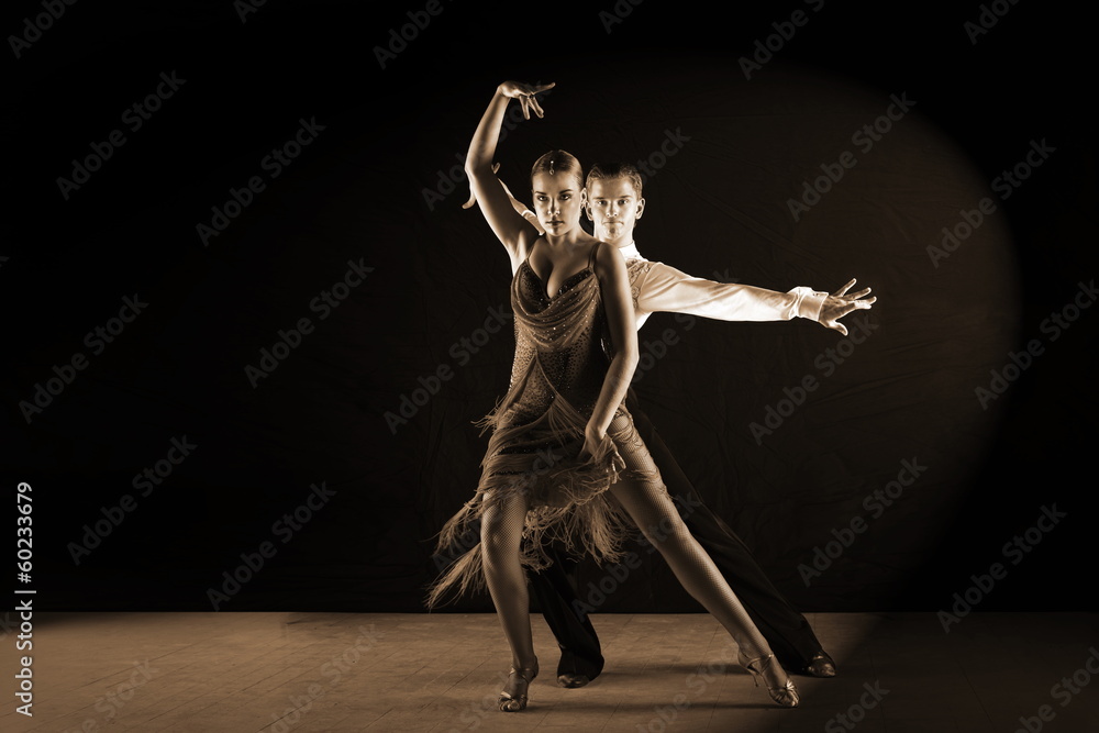 Obraz premium Latino dancers in ballroom against black background