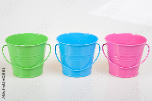 green, blue and pink pails, buckets