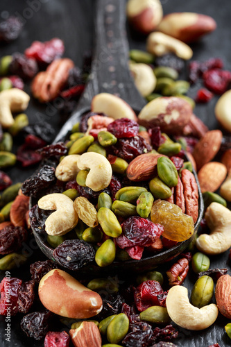 Nuts and dried fruits mix on wooden spoon