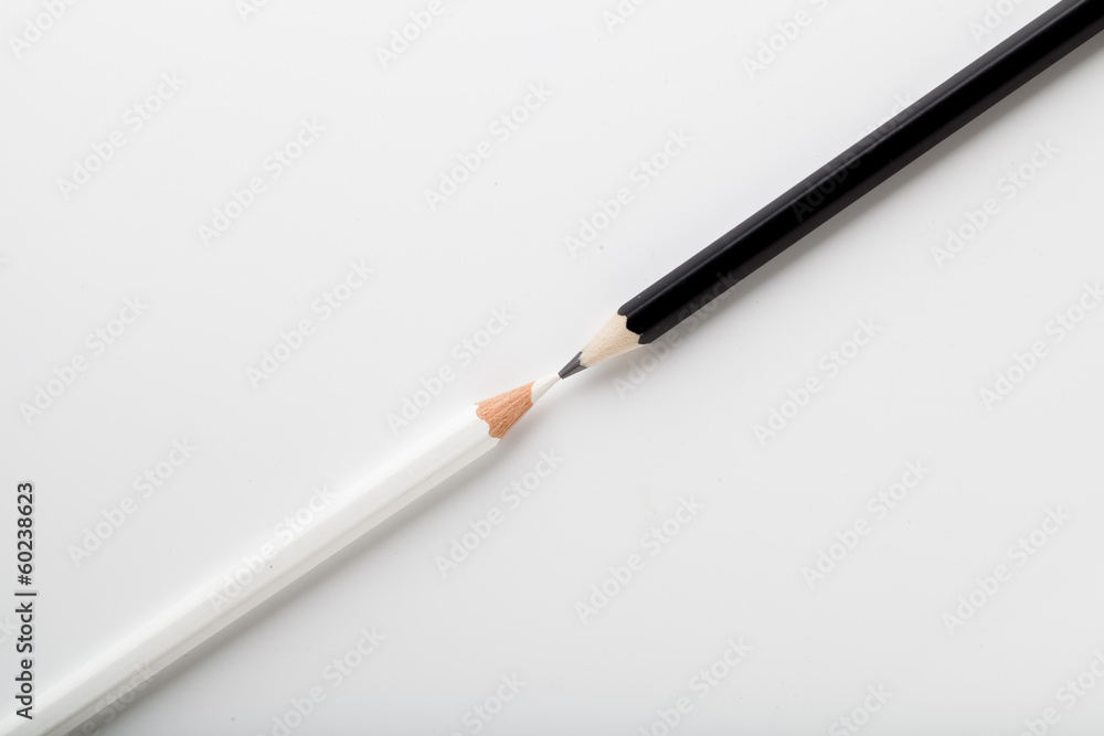 Fototapeta premium white pencil and black pencil placed on opposite color