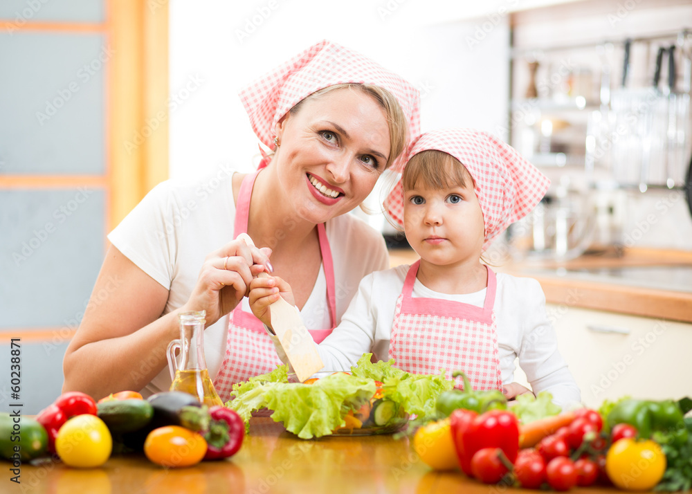 mother teaching kid daughter mixing salad at kitchen mother teaching kid daughter mixing salad at kitchen