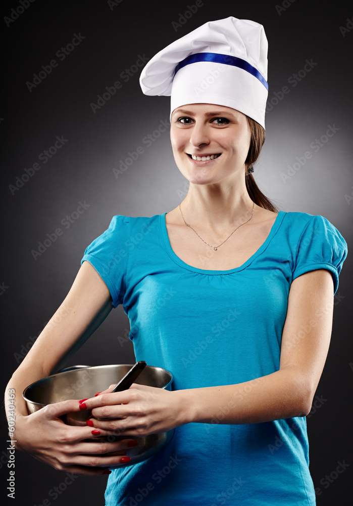Cheerful woman chef wearing hat and holding a po Cheerful woman chef wearing hat and holding a po
