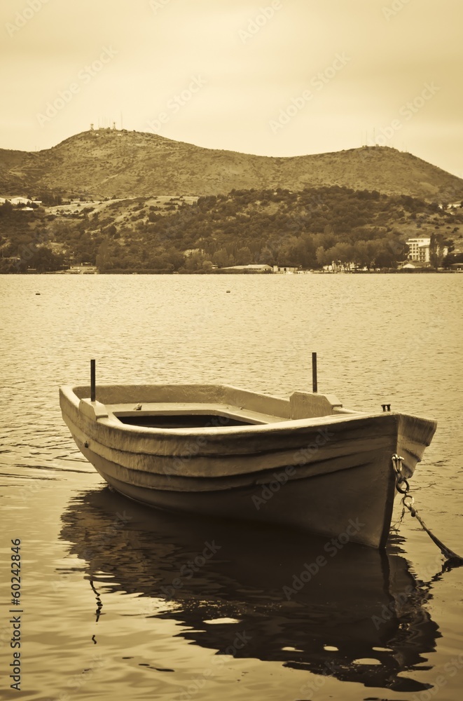 Lonely boat on the lake. Retro styled photo