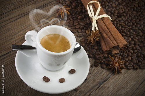cup of coffee with heart of steam, cinnamon sticks and anise