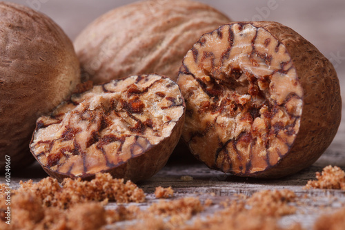 Canvastavla sliced ​​and grated nutmeg on an old wooden table. macro