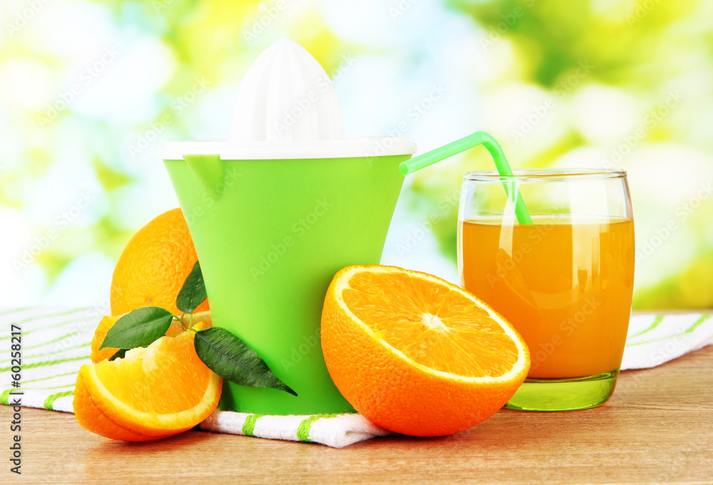 Naklejka premium Citrus press, glass of juice and ripe oranges