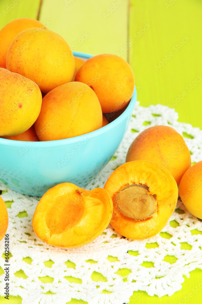 Fresh natural apricot in bowl on green wooden table Fresh natural apricot in bowl on green wooden table