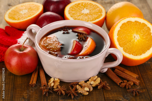 Fragrant mulled wine in pan on wooden table close-up