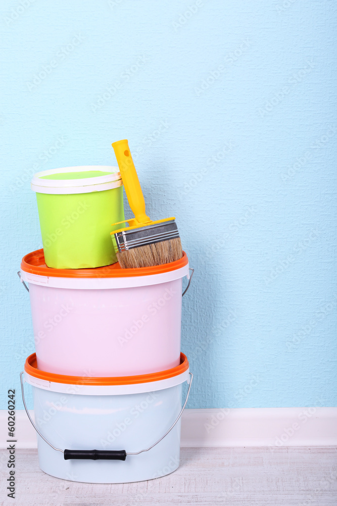 Paints and paintbrush on floor in room on wall background Paints and paintbrush on floor in room on wall background