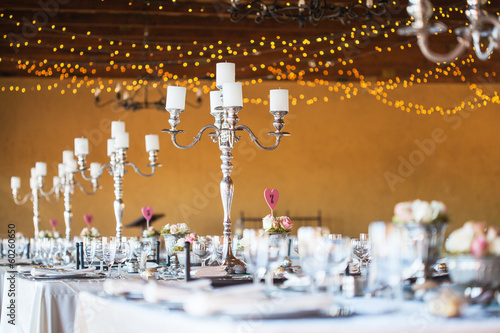 Wedding reception hall with decor including candles, cutlery and