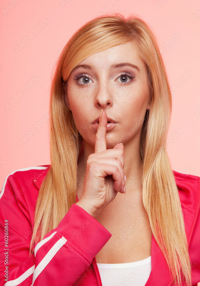 Secret woman. Fitness girl showing hand silence sign Secret woman. Fitness girl showing hand silence sign