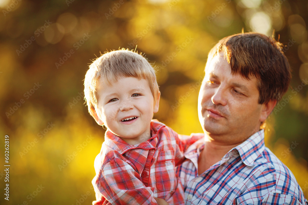 Dad and son walking in the park in summer Dad and son walking in the park in summer
