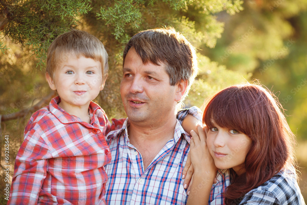Fototapeta premium Young family walking in the summer park