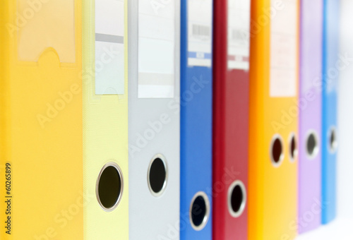 row of colorful ring binders on shelf photo