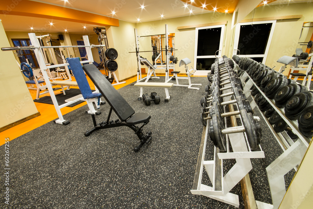 Interior view of a gym with equipment and weights.