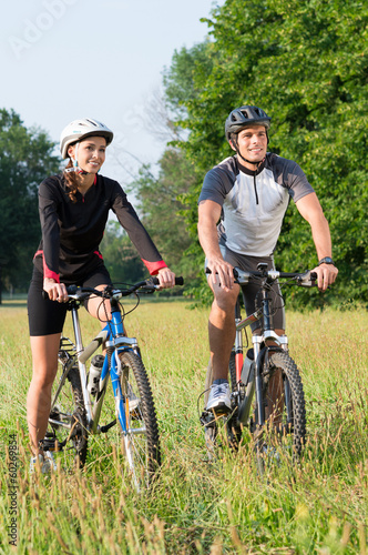 Young Couple With Bicycle In Meadow