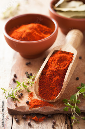 red paprika powder spice in wooden scoop