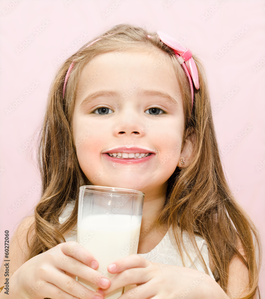 Smiling cute little girl with glass of milk