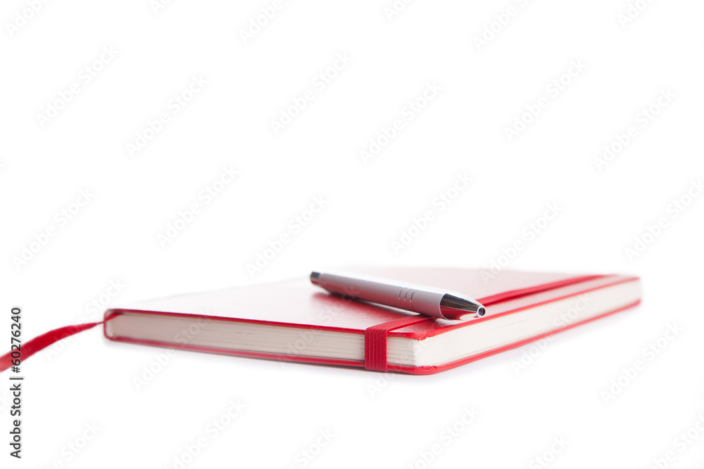 Notebook and pen in composition in red and white Notebook and pen in composition in red and white