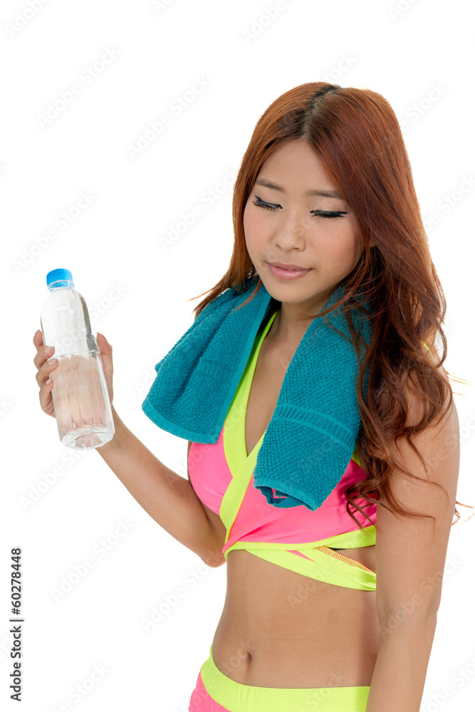 Attractive Asian woman with water bottle and towel after exercis Attractive Asian woman with water bottle and towel after exercis