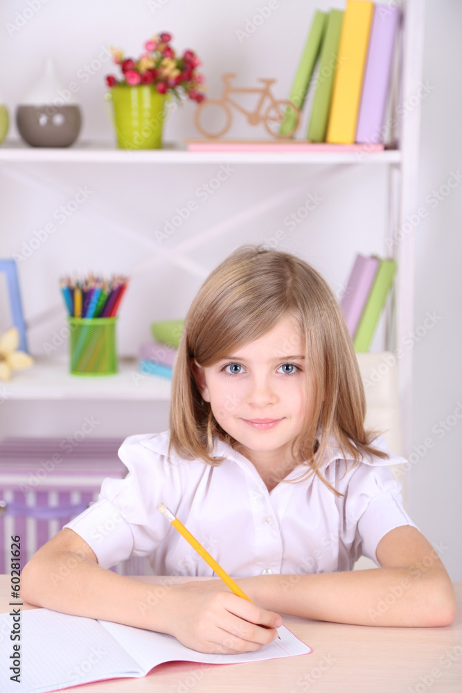 Little girl sitting at desk in room Little girl sitting at desk in room