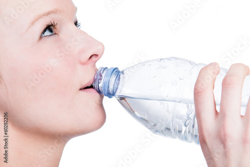 Sportliche junge Frau trinkt Wasser aus einer Flasche photo