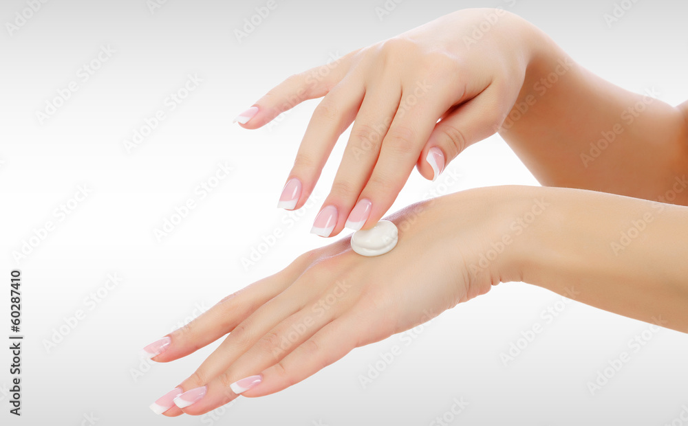 Fototapeta premium Female hands with a moisturiser on light grey background