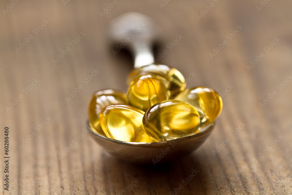 Cod liver oil omega 3 gel capsules isolated on wooden background Cod liver oil omega 3 gel capsules isolated on wooden background
