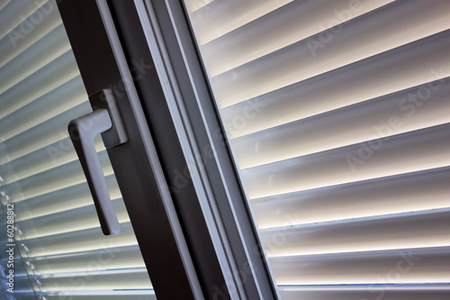 Jalousien als Sonnenschutz am Fenster