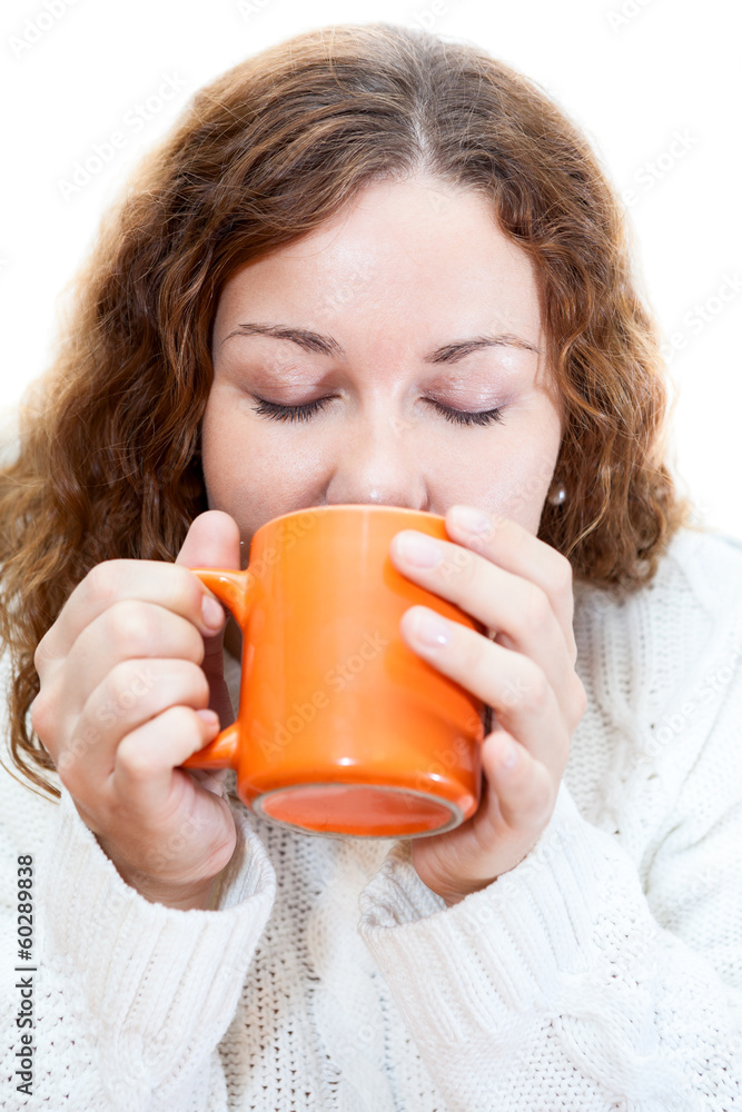 Young woman drinking from orange mug, isolated on white Young woman drinking from orange mug, isolated on white