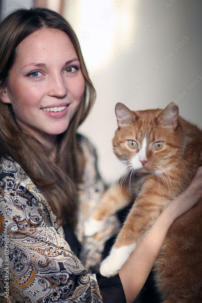 portrait of a beautiful girl with a red cat